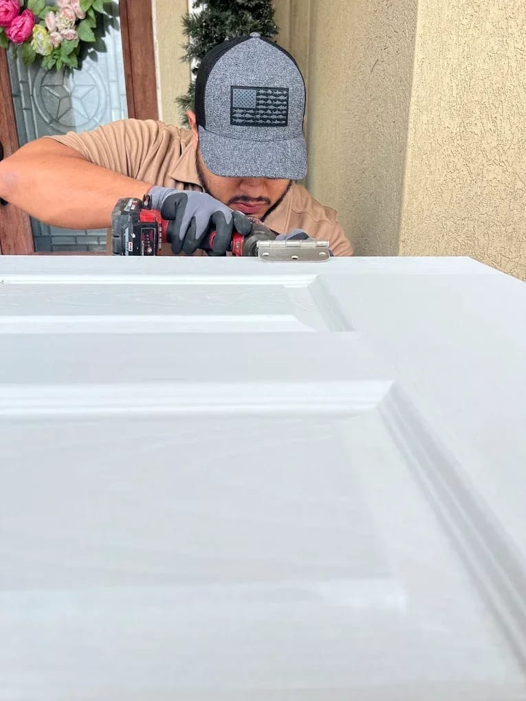 Technician using a power tool to fit hardware