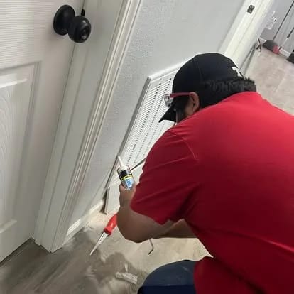 Technician applying a clean sealant bead beside trim