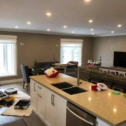 Living and kitchen area during preparation, with tools and unfinished wall details visible