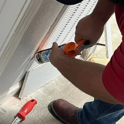 Technician working around an exterior window frame
